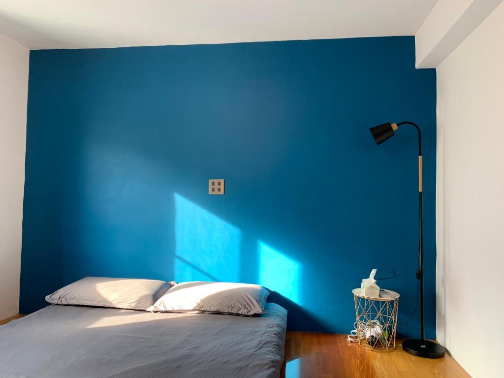 ein blaues Schlafzimmer mit einem Bett mit blauer Wand in der Unterkunft 琉浪潛水背包客棧 Drift Diving Hostel in Xiaoliuqiu