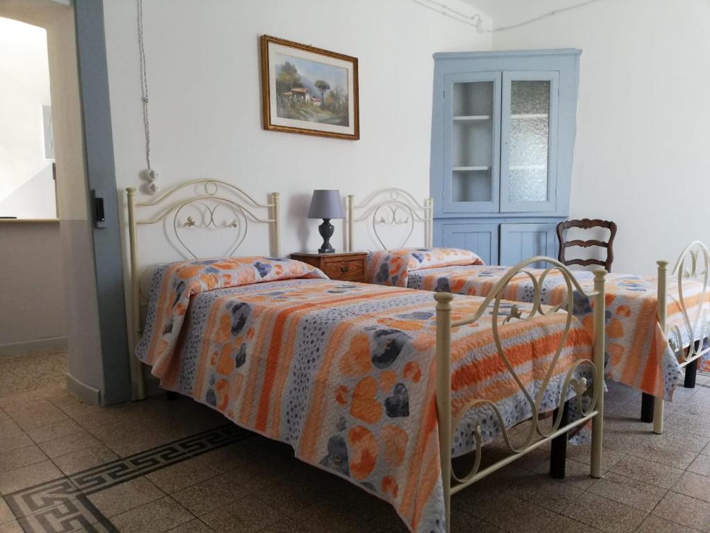 a bedroom with two beds and a blue door at Le dimore del Mercante in Luco neʼ Marsi