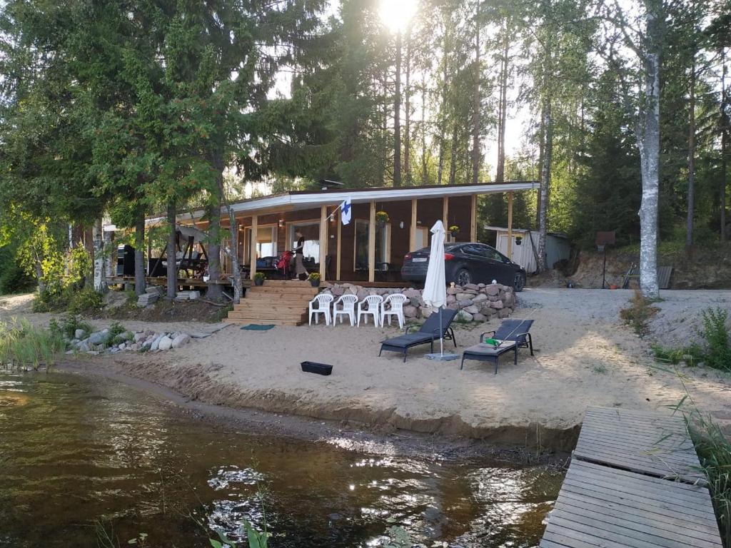a house with a table and chairs next to a river at Tilhi 1 Cottage in Piojärvi