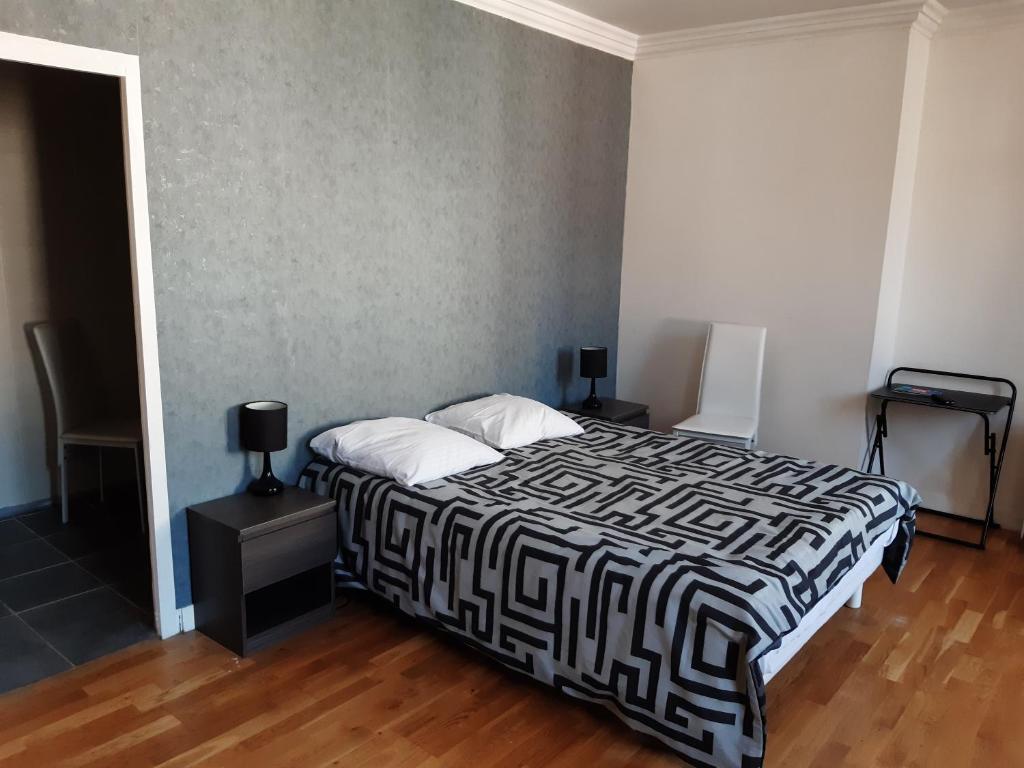 um quarto com uma cama com um cobertor preto e branco em La Boule d'Or em Bourganeuf