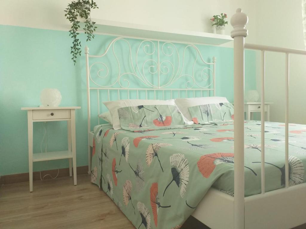 ein Schlafzimmer mit einem weißen Bett und einer Tagesdecke mit Vögeln in der Unterkunft Casita verde vista mar in Parque Holandes