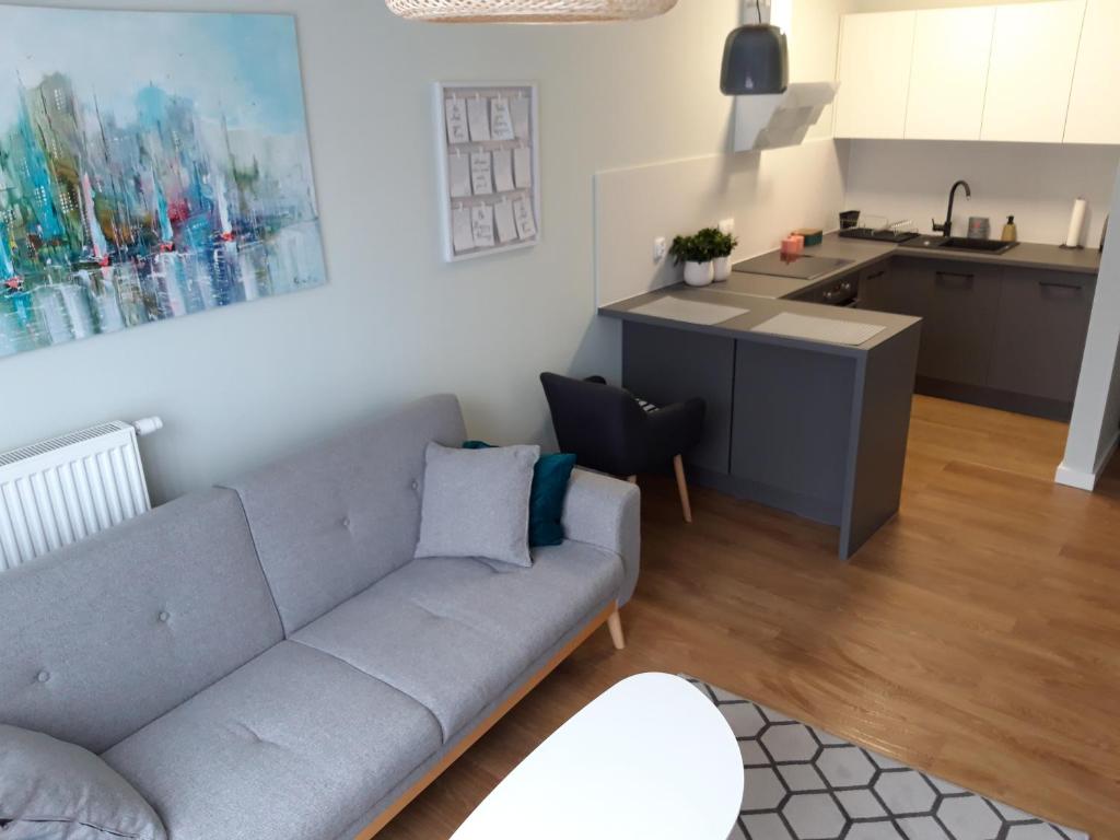 a living room with a couch and a kitchen at Apartament Smart in Szczecin