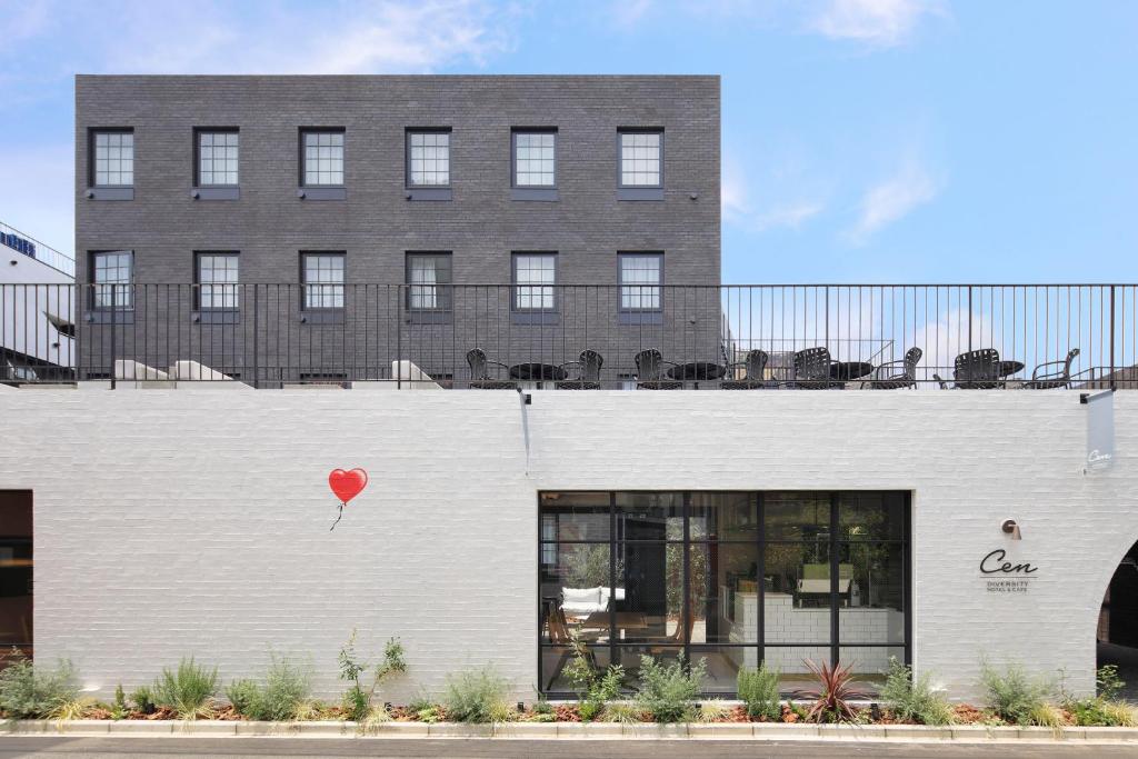 a red balloon on the side of a white building at HOTEL CEN in Tokyo