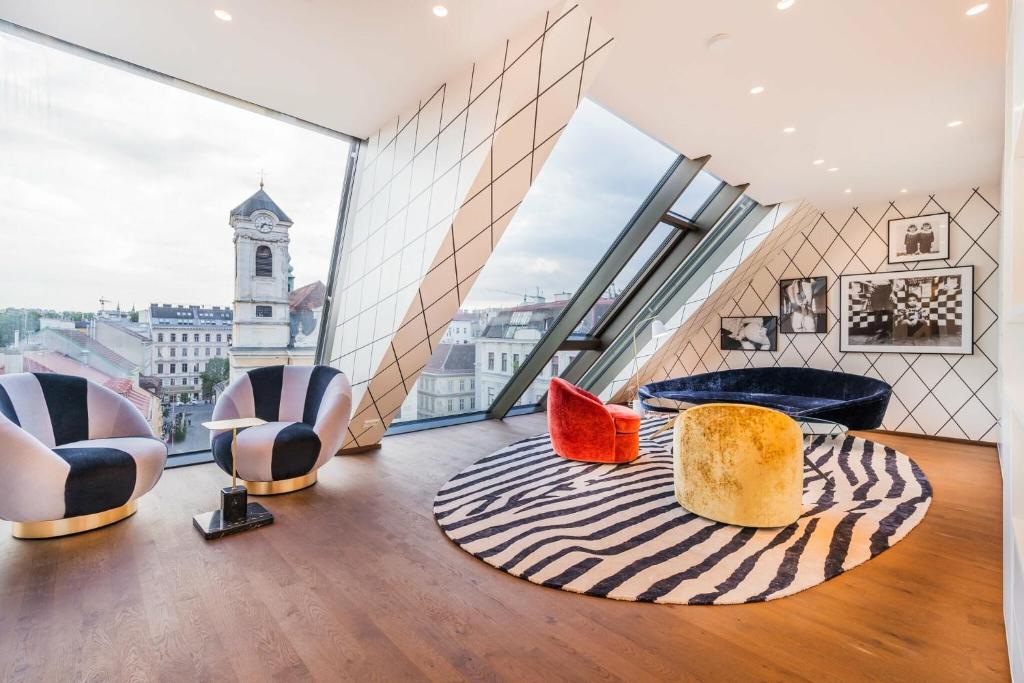 ウィーンにあるLuxury Residence near Parlament in @YourViennaの椅子2脚と大きな窓が備わる客室です。