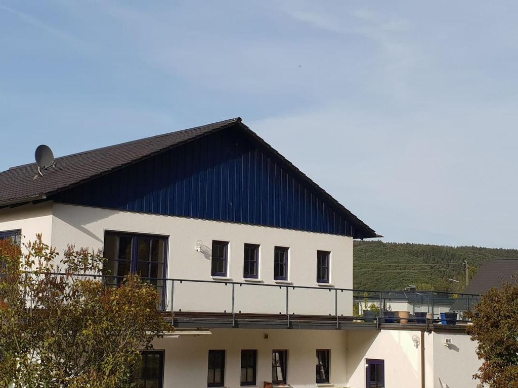 a white building with a blue roof at Ferienwohnung Siegaue in Windeck