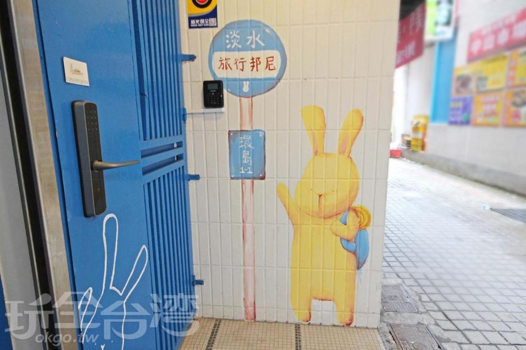 een muurschildering van een konijn op een muur naast een deur bij Tourist Bunny Hostel in Tamsui