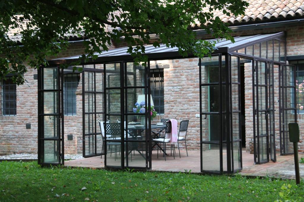 a greenhouse with a table and chairs in a yard at BORGO GIUSTINIANI Mora Pero Melo in San Martino di Venezze