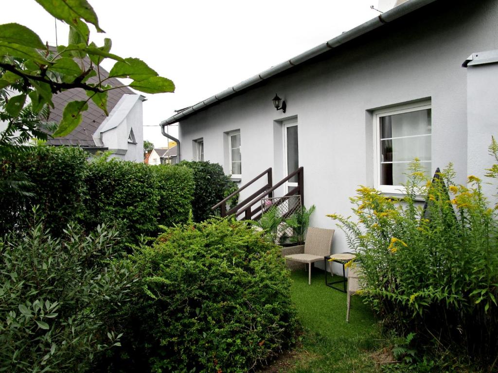 una casa blanca con un patio con arbustos en Holiday House Smetánek, en Bruntál