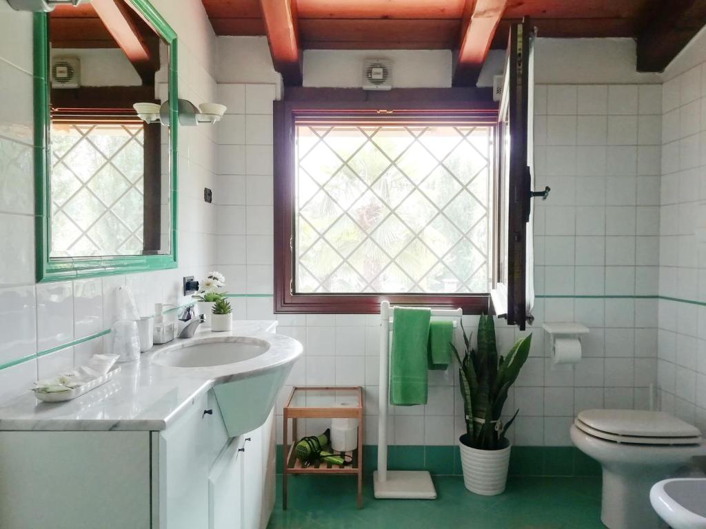 baño con lavabo y aseo y ventana en Villa Stefania, en Noventa Padovana