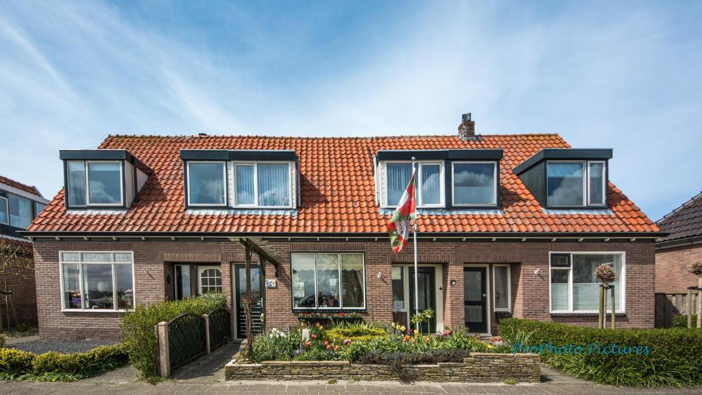 une maison en briques avec un toit orange dans l'établissement B&B 'Four Seasons', à Julianadorp