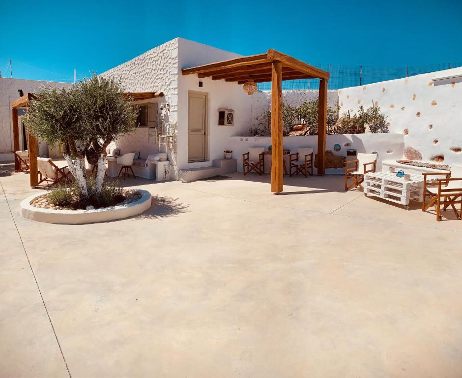 un patio con mesas y sillas y un pabellón en Aeris en Koufonisia