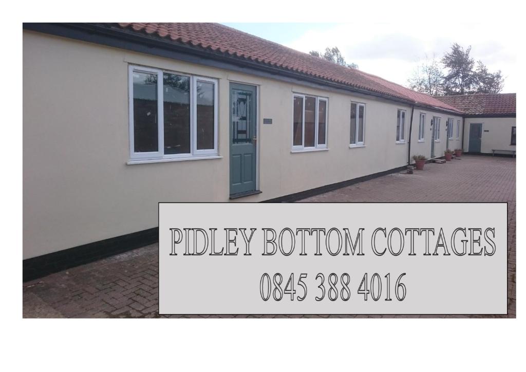 a white house with a sign that reads policy bottom containers at Pidley Bottom Cottages - Luxury SC rooms - Fully furnished and equipped - KITCHEN - towels and linen included in Pidley