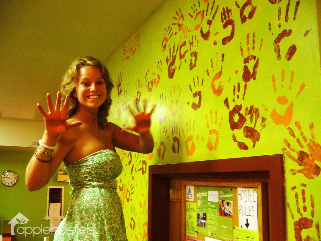 a woman standing in a room with her hands in the air at Apple Hostels of Philadelphia in Philadelphia