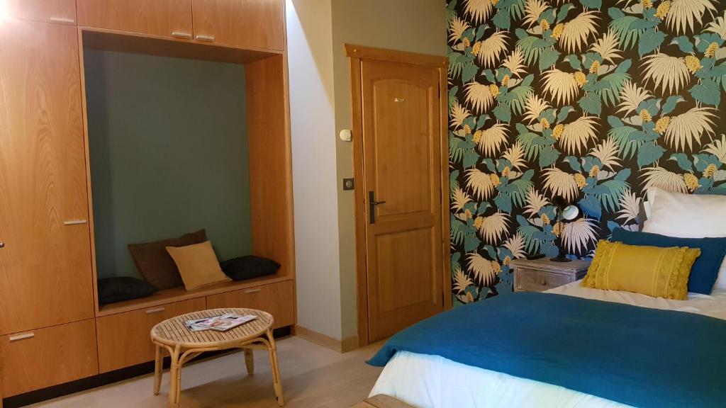a bedroom with a bed with a blue blanket and a wall at Maison d hotes Lapitxuri in Arcangues