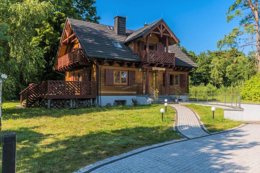 a wooden house with a path leading to it at Komfortowy Leśny Dwór in Sztutowo
