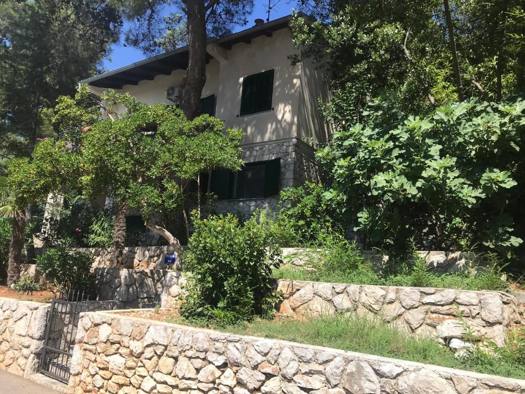 a stone wall in front of a house at Apartment Sunshine in Mali Lošinj