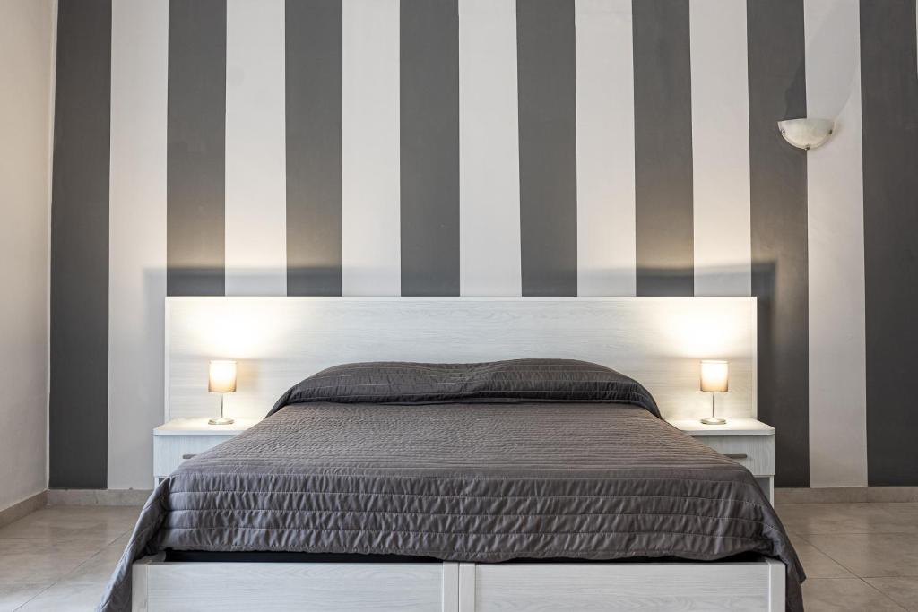 una camera da letto con un grande letto con pareti a righe di Hotel Costanza a Catania