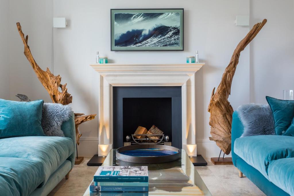 sala de estar con 2 sofás azules y chimenea en Merchants House, en Salcombe