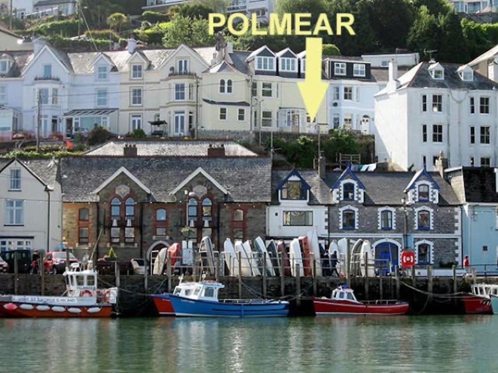 um grupo de barcos ancorados num porto com edifícios em Polmear Harbour View With Terrace em Looe