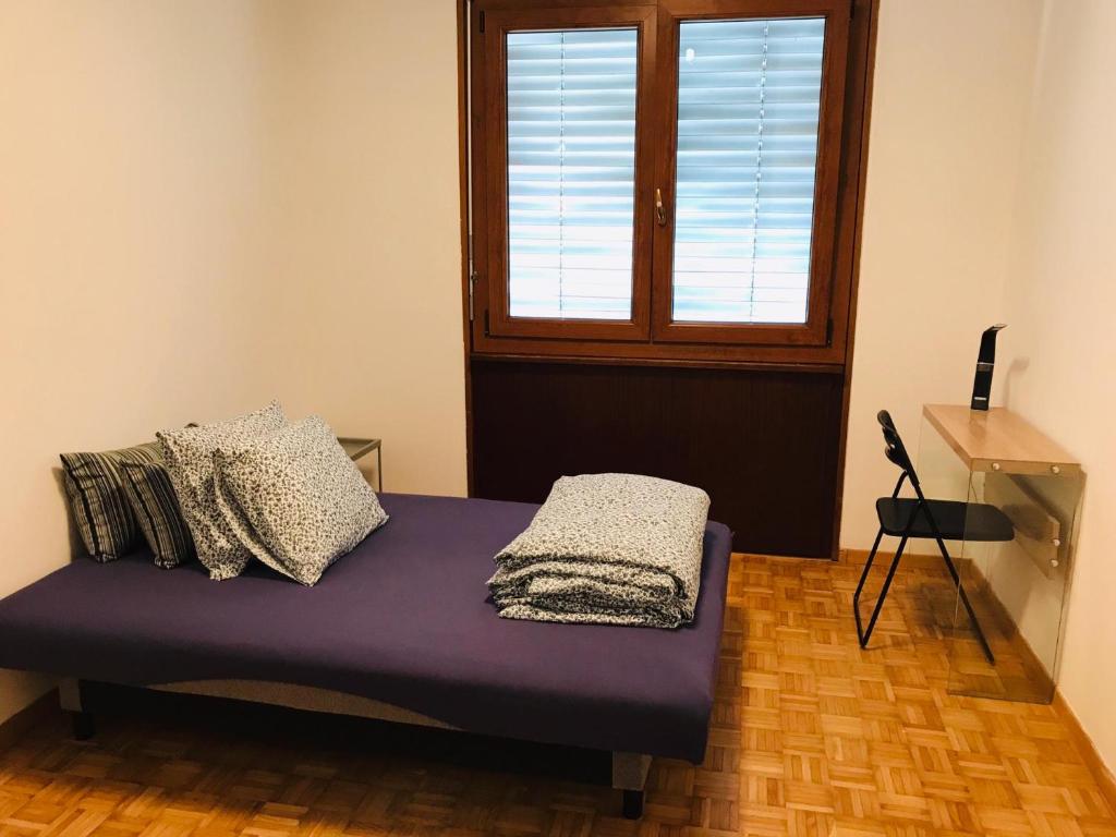 a bedroom with a bed, chair and a window at budget 33A in Lugano