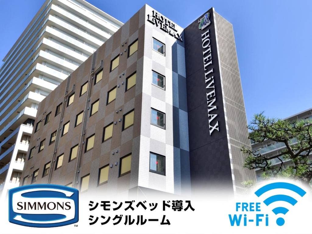 a building with a sign on the side of it at HOTEL LiVEMAX Toyosu-Ekimae in Tokyo