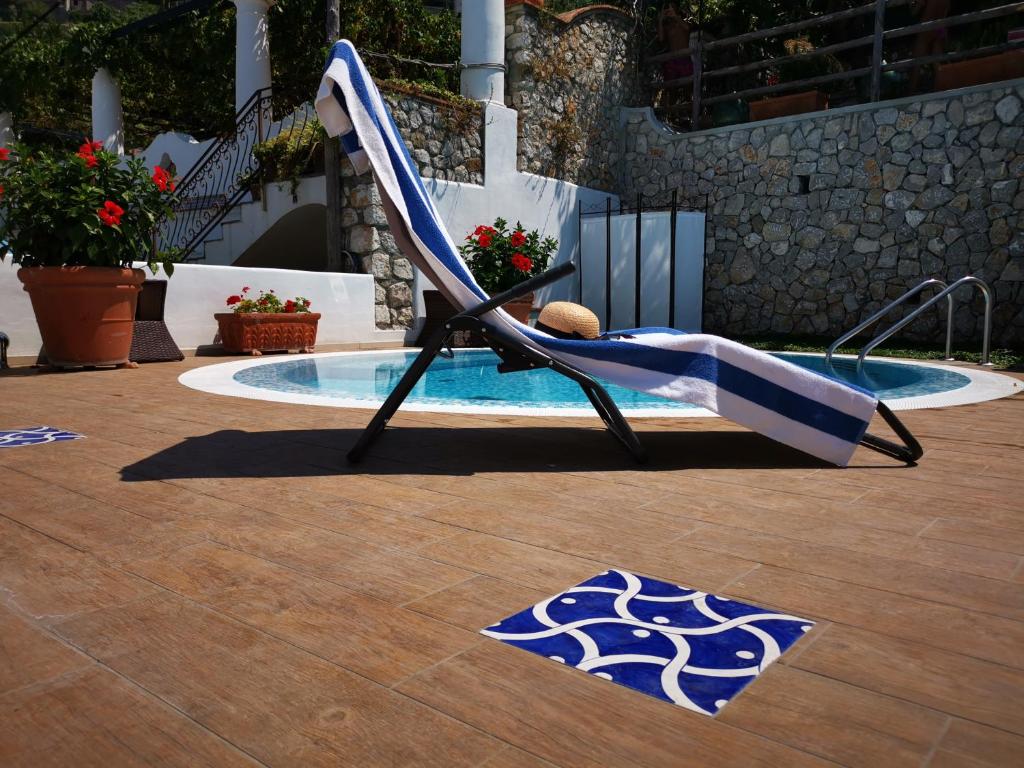 einen Liegestuhl neben einem Pool in der Unterkunft Villa Patrizi in Capri