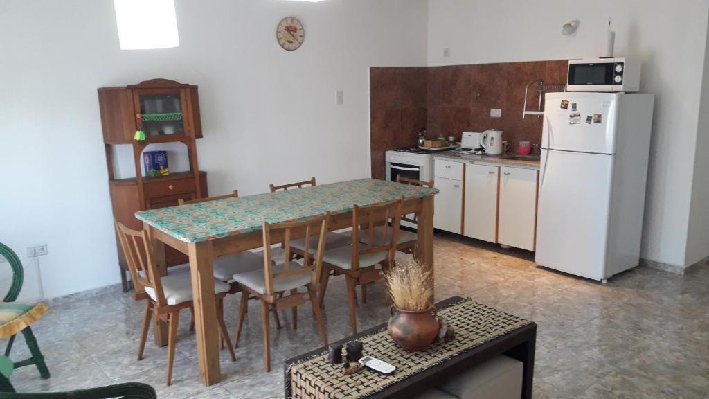 uma cozinha com uma mesa e um frigorífico branco em departamento tandil em Tandil