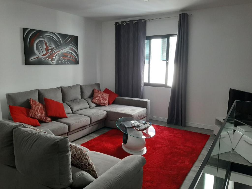 sala de estar con sofá y alfombra roja en Grannies House, en Machico