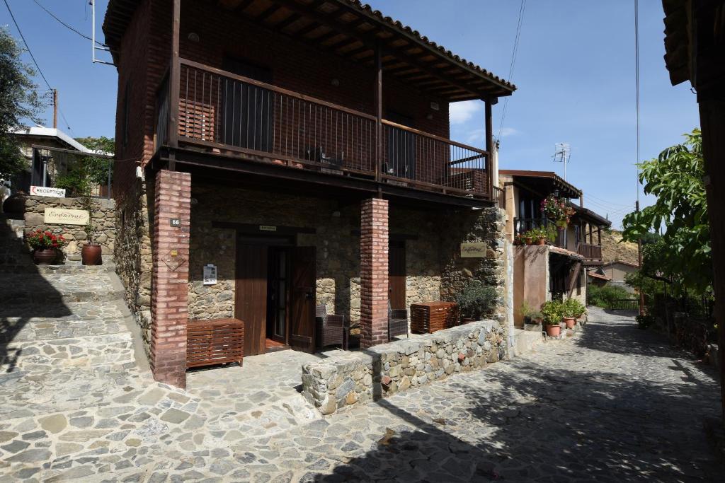 un edificio antiguo con balcón en una calle en Enipnion Apartments, en Kakopetria