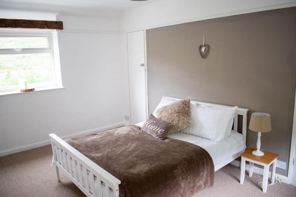 a bedroom with a bed with a window and a bedskirtspectspectspectspects at Afan Valley Home - Contractor Accommodation in Port Talbot