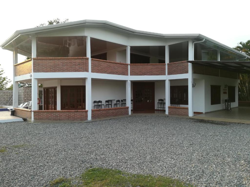 un gran edificio de ladrillo con un gran porche delantero en Finca Campestre El Encanto en Villavicencio