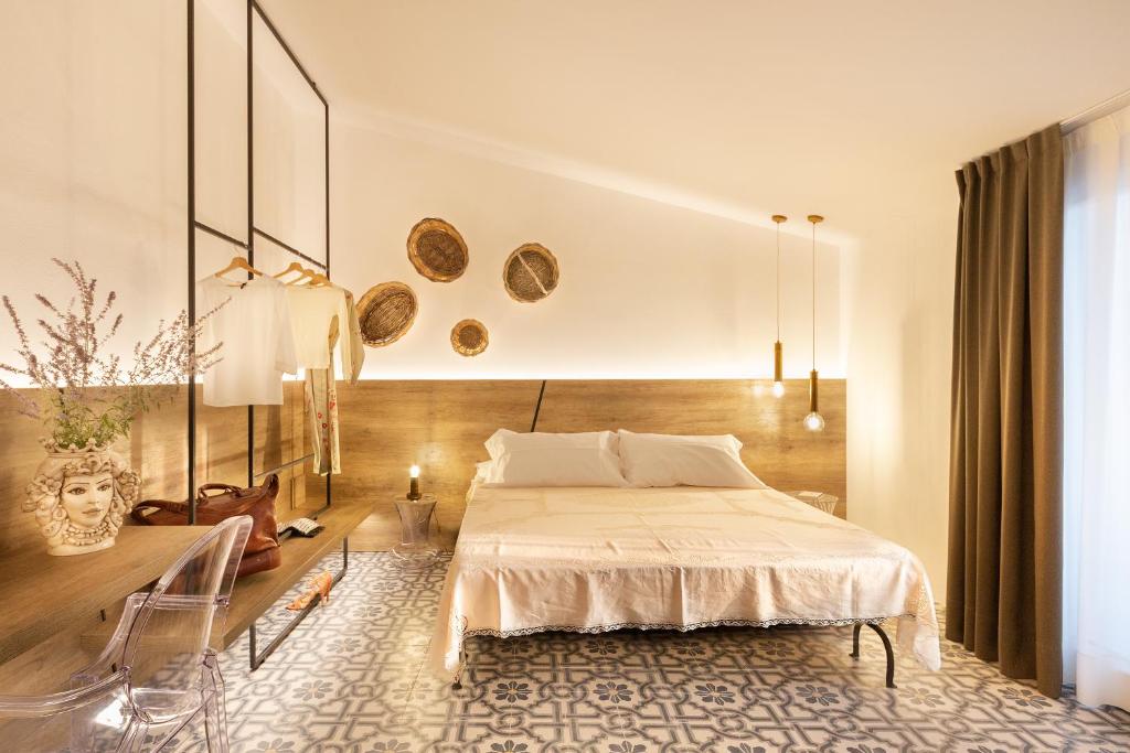 een slaapkamer met een bed en een tafel bij Filinona B&B in Noto