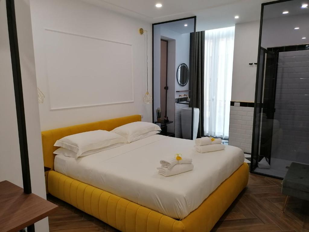 una camera da letto con un grande letto bianco con accenti gialli di Al Raggio di Sole in Costiera a Maiori