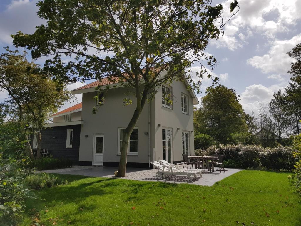 una casa blanca con una mesa de picnic en el patio en De Haas, en Oostkapelle