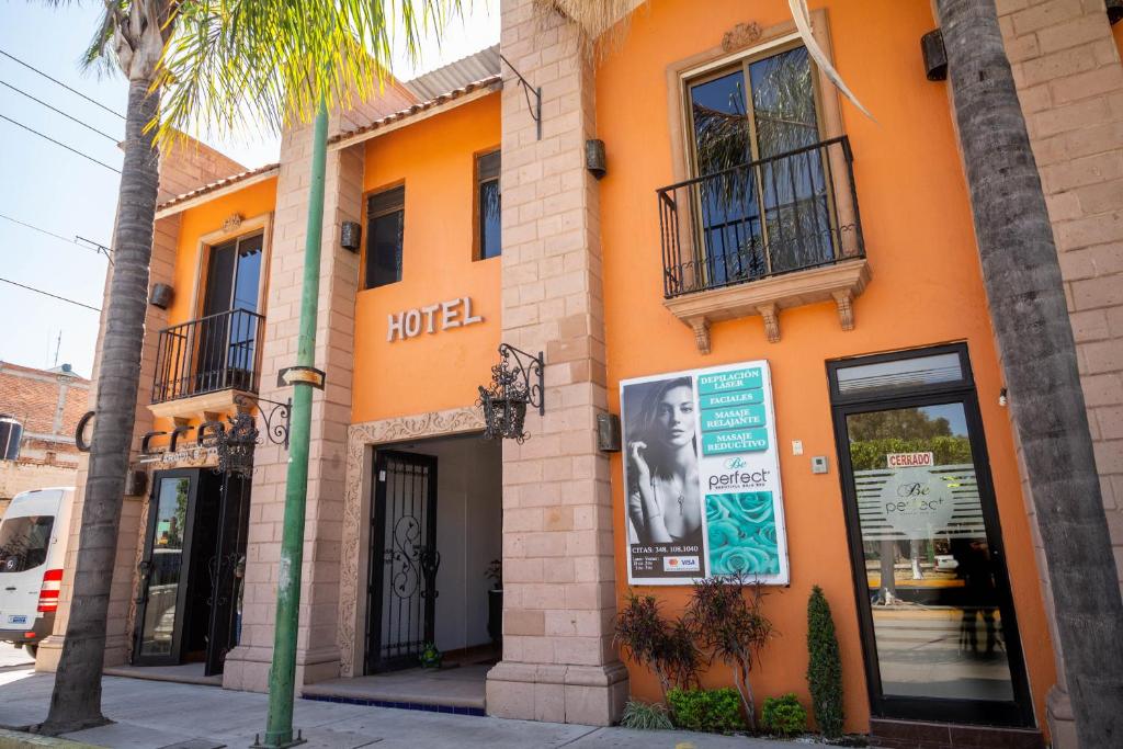 an orange building with a sign that reads motel at Hotel Degollado in Degollado