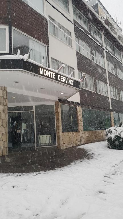 um edifício com um sinal na neve em Monte Cervino Hotel em San Carlos de Bariloche