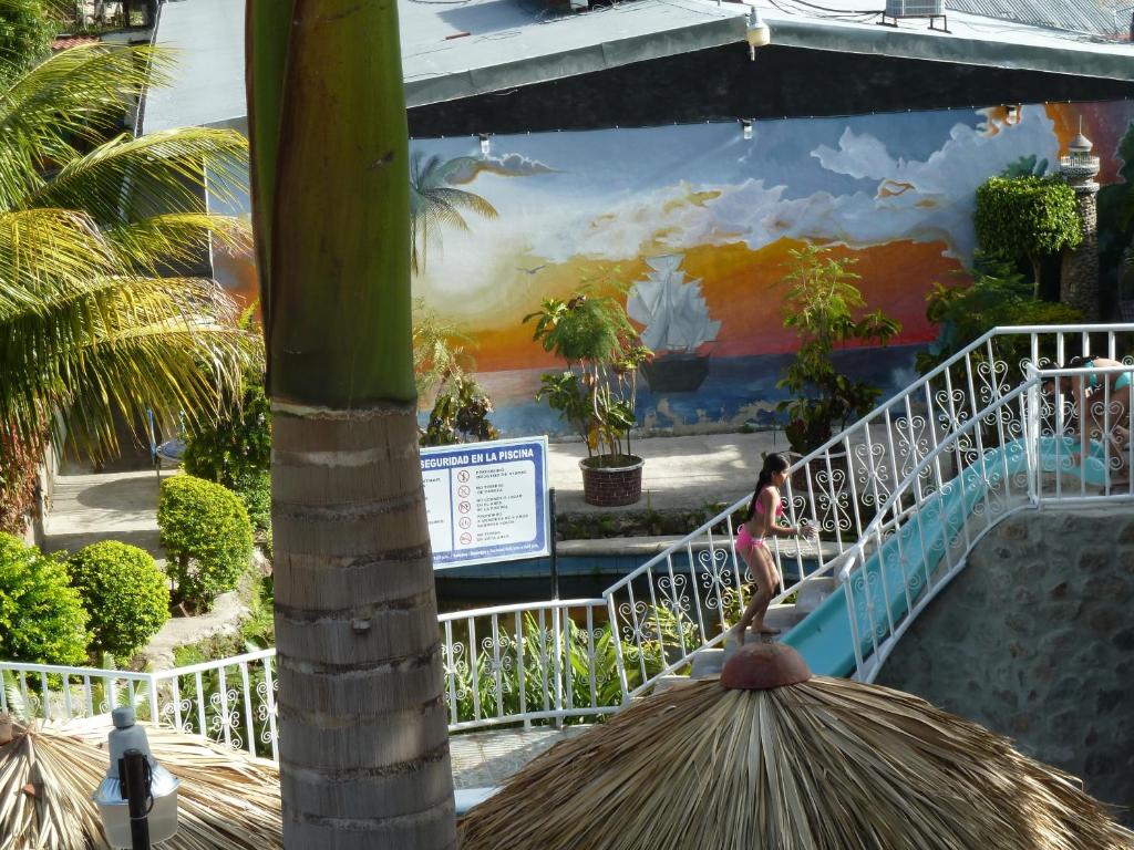 a wall with a painting of a palm tree at Apart Hotel Acuarious de Luis in Estelí