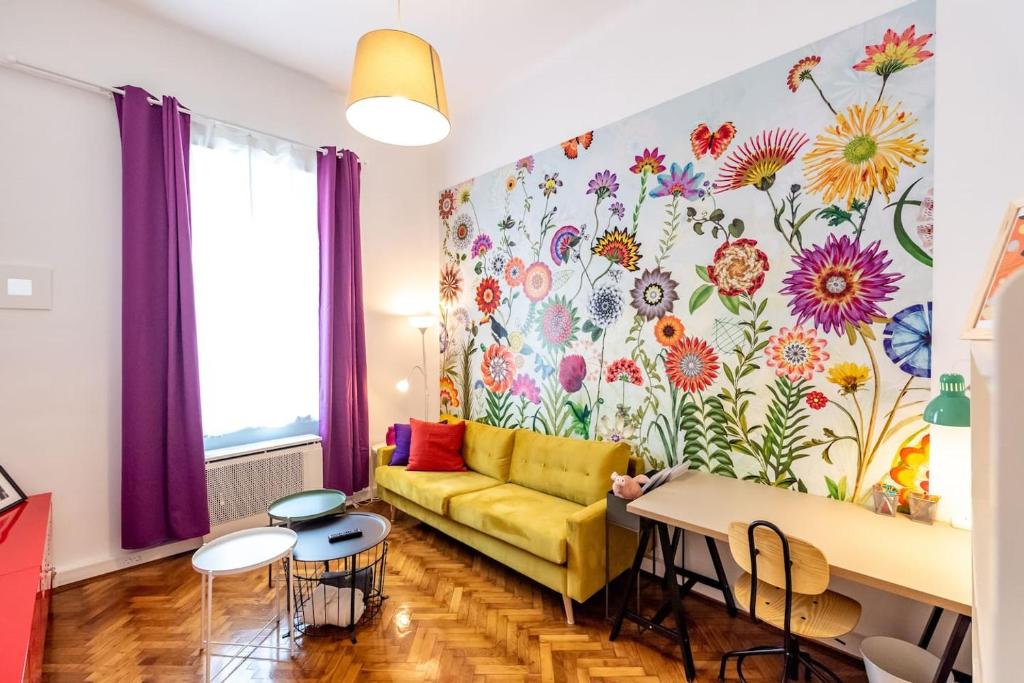 a living room with a yellow couch and a floral wall at K5 - The happy home in the Nightlife Zone in Budapest