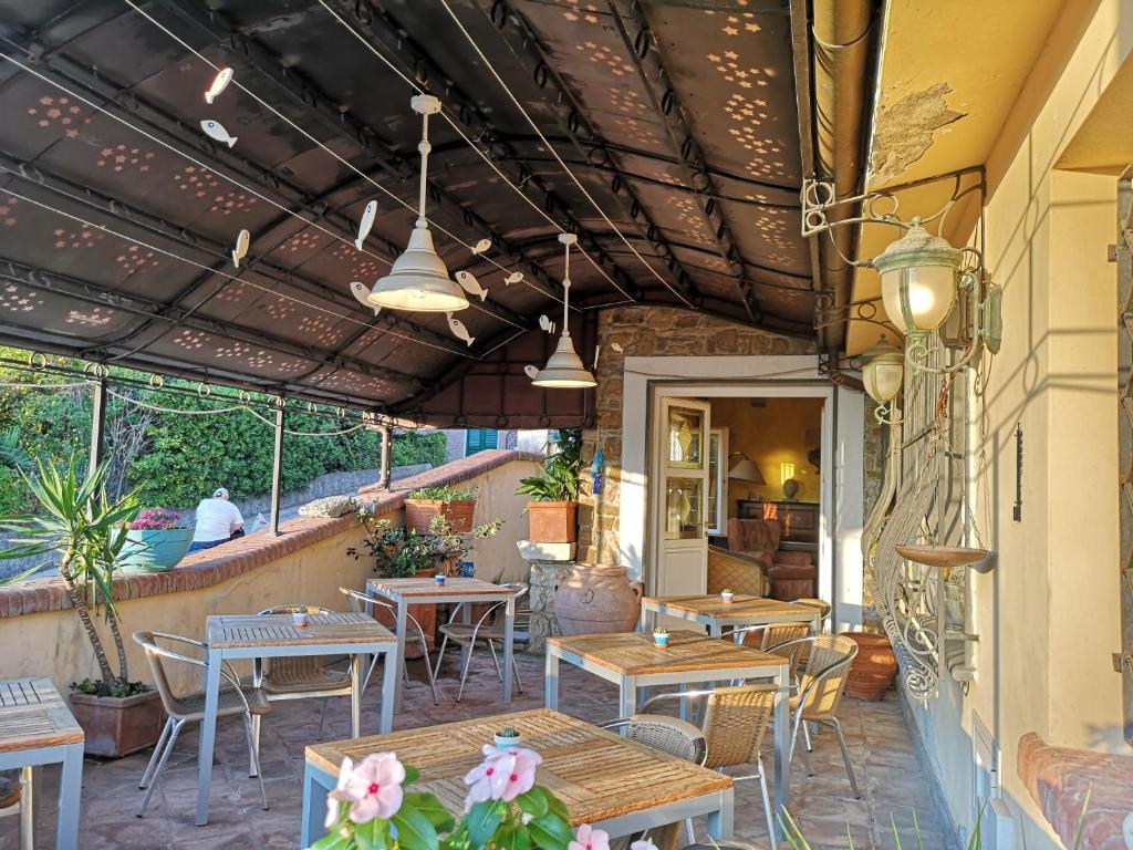 eine Restaurantterrasse mit Tischen, Stühlen und Lampen in der Unterkunft Locanda Miranda in Tellaro