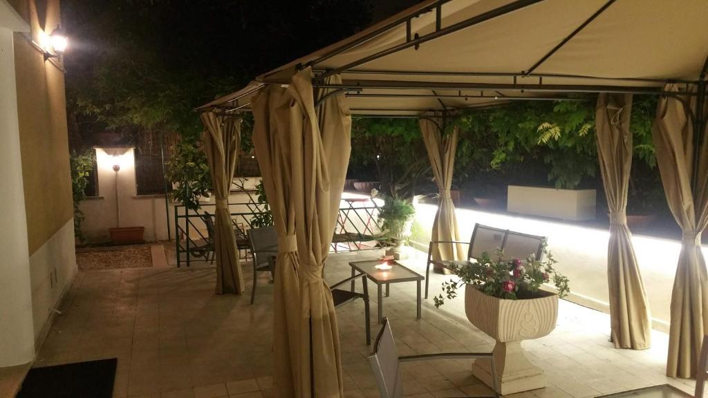 a patio with an umbrella and a table with flowers at GARDEN HOUSE - Luxury Guest House - Self check-in only in Rome