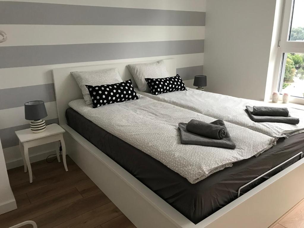 - un grand lit avec des oreillers en noir et blanc dans l'établissement Bastion Gdański, à Gdańsk