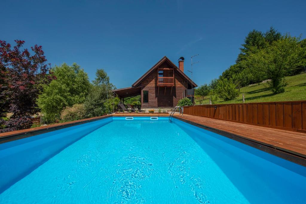a swimming pool with a house in the background at Holiday home Romana in Sveti Ilija