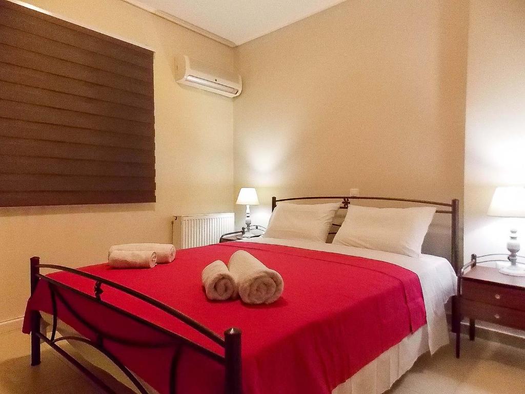 a bedroom with a red bed with towels on it at Nea Filadelfia- Spacious Apartment with Garden in Athens