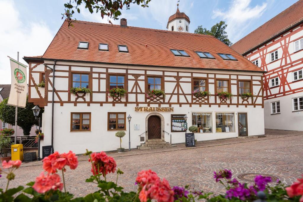 ein Gebäude in einer Stadt mit Blumen davor in der Unterkunft Hotel-Restaurant Straussen in Harburg