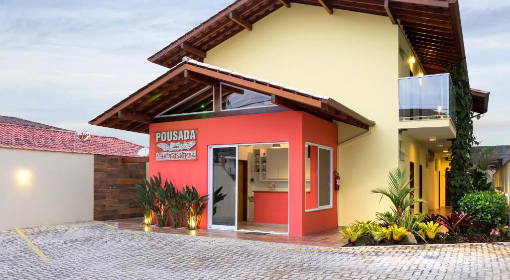 uma casa com uma fachada vermelha e amarela em Pousada Villa Peixes do Mar em Ubatuba