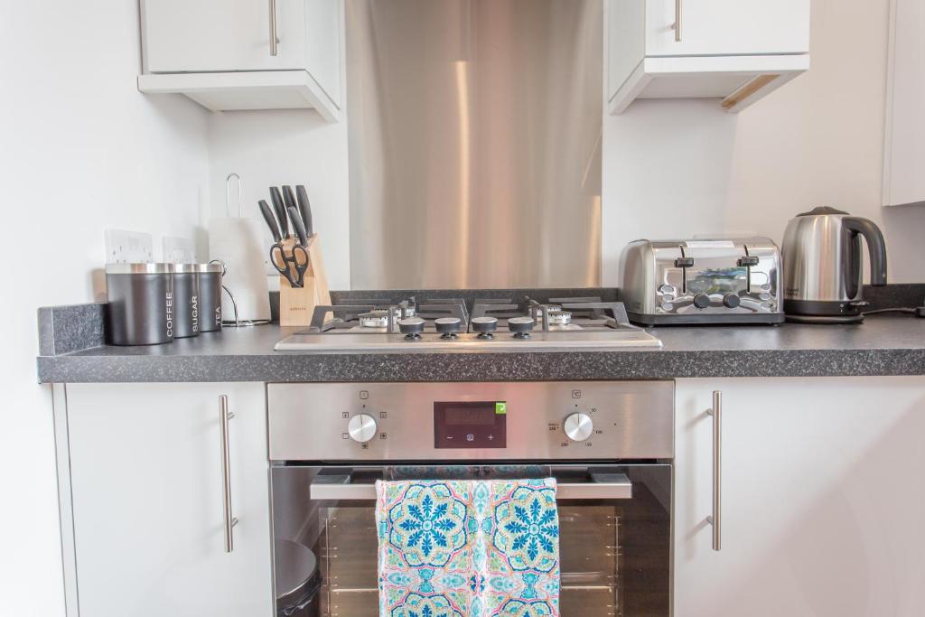 a kitchen with a stove top oven in a kitchen at Rana Court Apts 1 & 2 Bed Apts close to Hospitals Business & Science Parks in Oxford