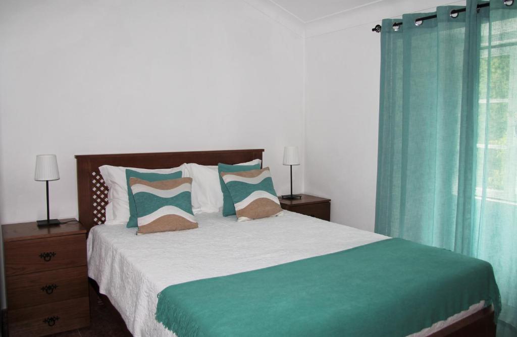 1 dormitorio con 1 cama grande y cortinas azules en Casa São João en São Salvador da Aramenha