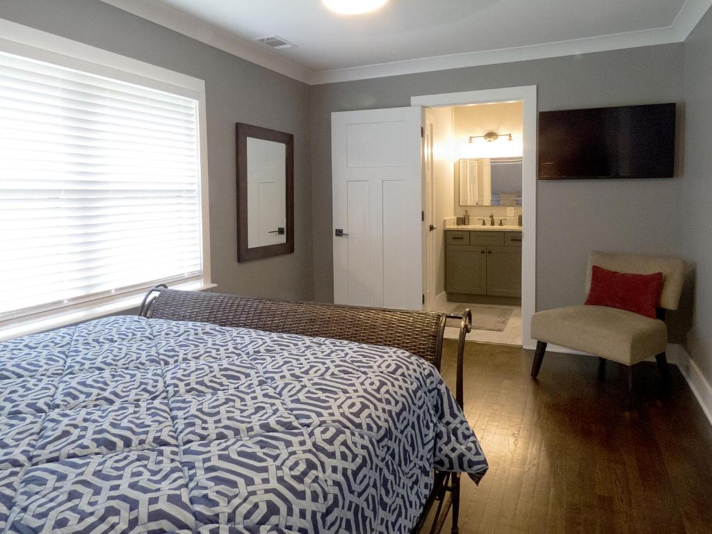 a bedroom with a bed and a chair and a bathroom at Modern Bungalow Near Downtown in Atlanta