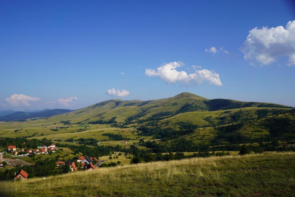 a view of a green hillside with a town and houses at Apartment Gajevi in Zlatibor