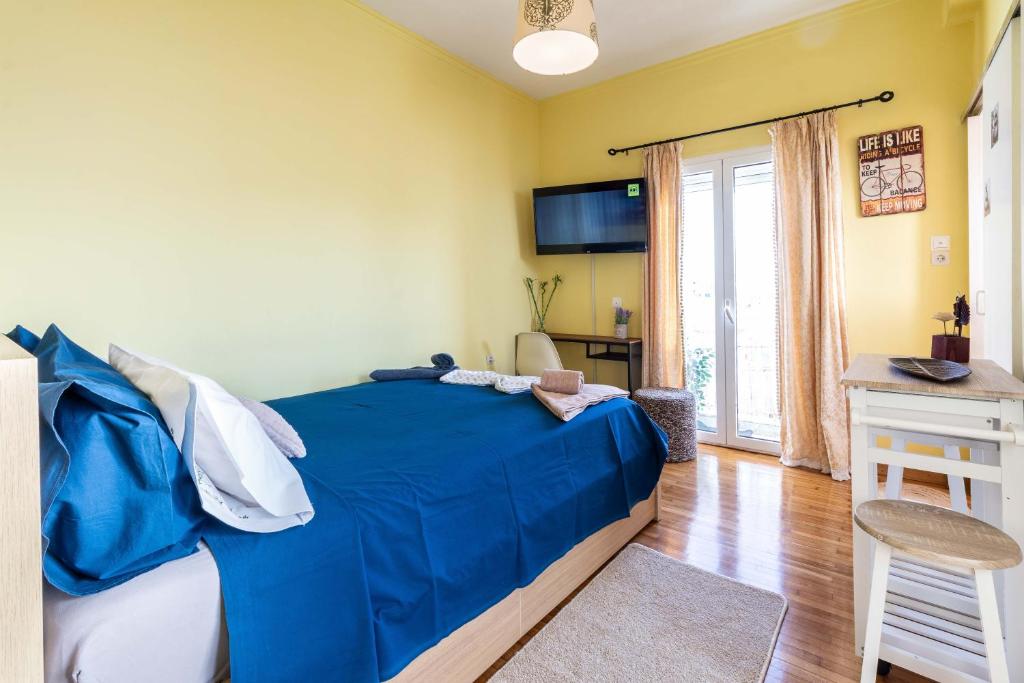 a bedroom with a bed with a blue comforter at Central 6th Floor Studio Near Metro & View&200mbps in Athens